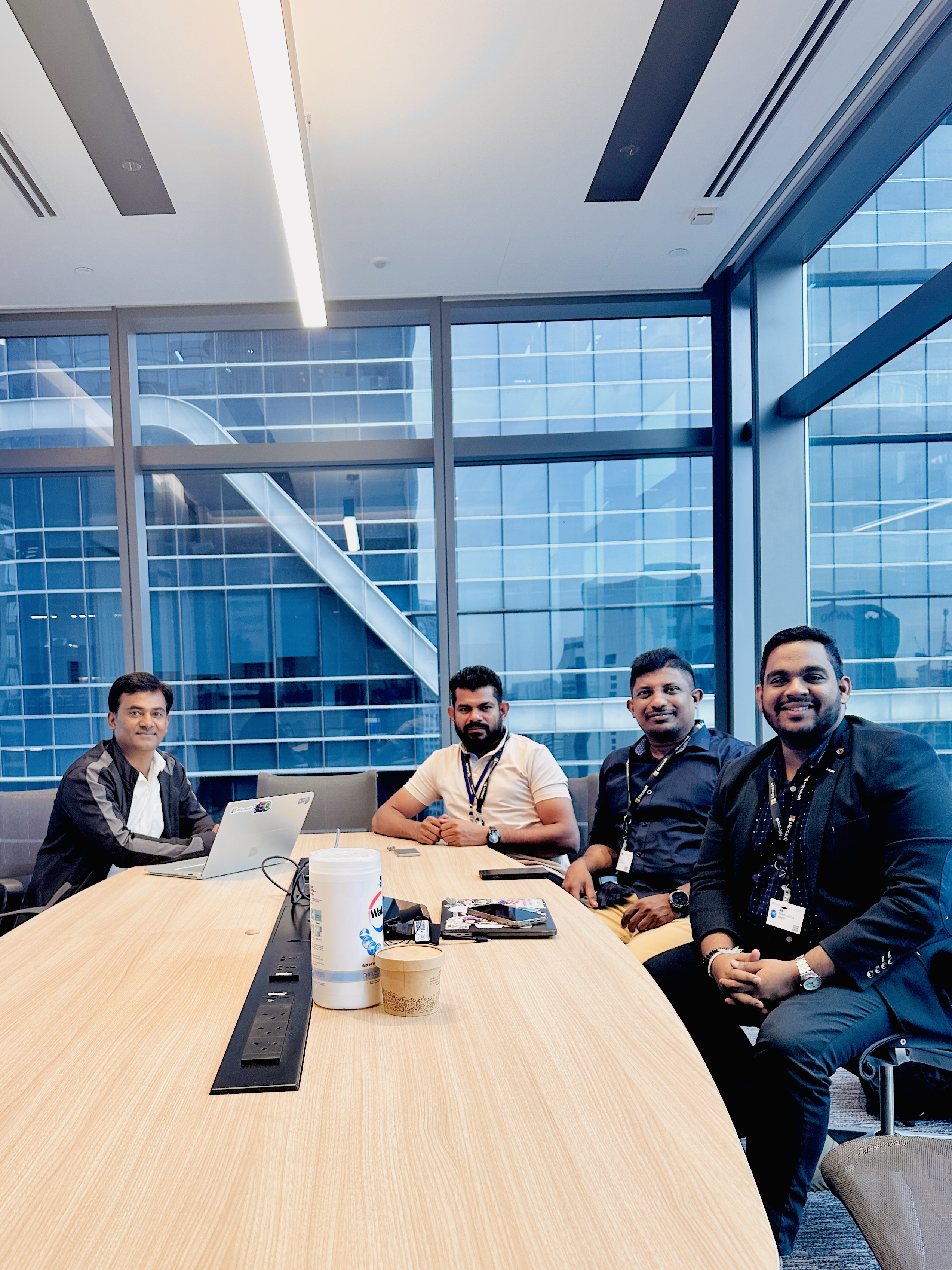 Four participants gathered around a meeting table in Singapore