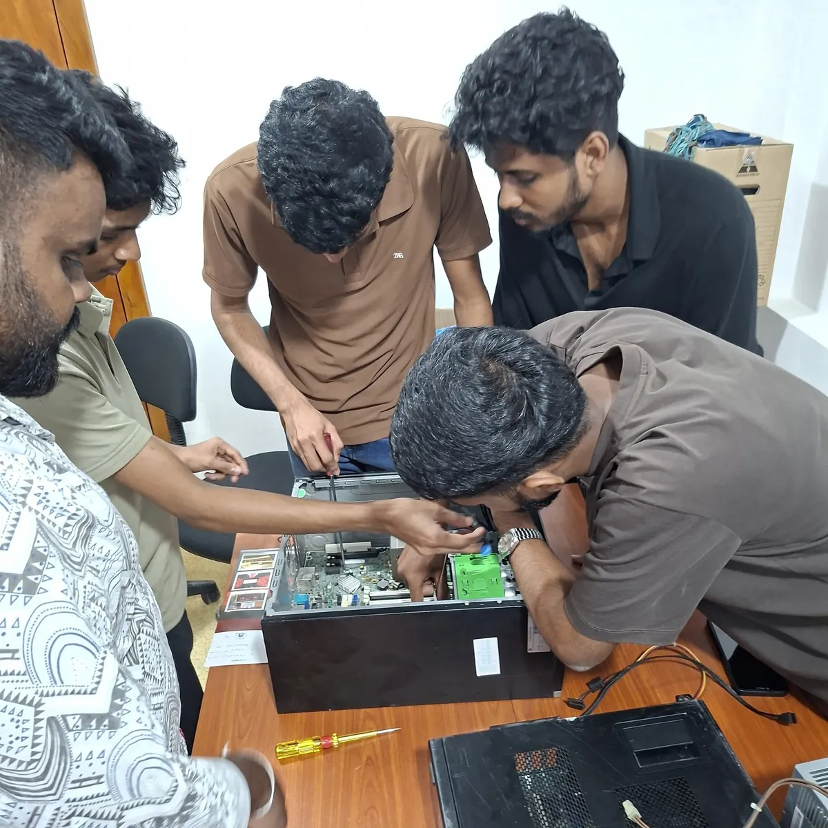 Students working together on an open laptop during a PCG practical session
